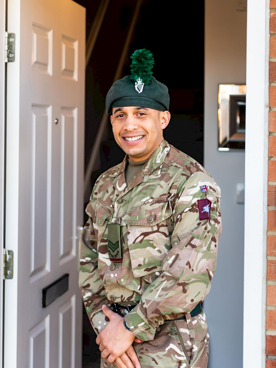 An armed forces gentleman stood in a doorway